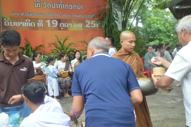 ພຣະສົງຈັບສະຫຼາກຮັບເຄື່ອງຖວາຍຈາກຍາດໂຍມ.