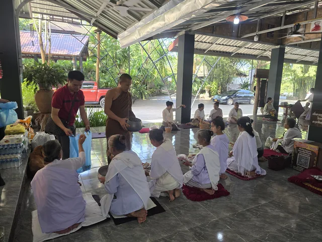 ພຣະສົງຮັບຂອງຖວາຍຈາກຍາດໂຍມພາຍໃນສາລາ.