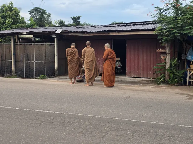 ພຣະສົງຍ່າງບິນທະບາດຜ່ານເຮືອນຂອງຊາວບ້ານ.