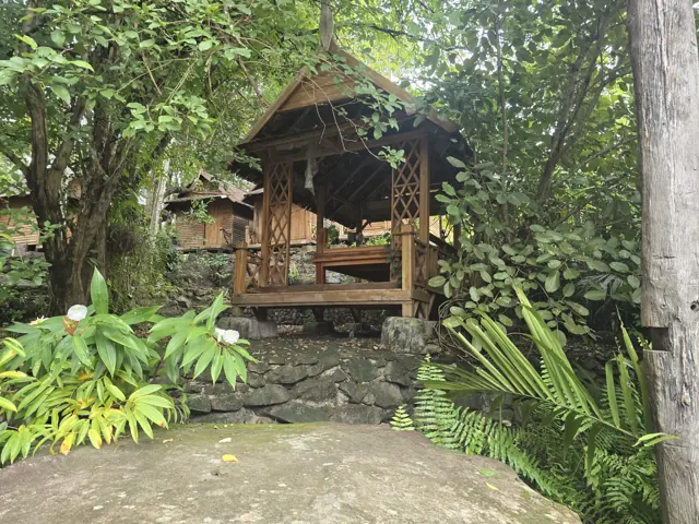 ສາລາໄມ້ນ້ອຍໃນມຸມສະຫງົບຮົ່ມເຢັນຂອງວັດ.